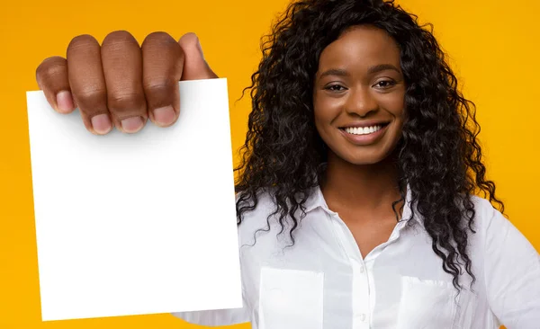 站在黄色背景下的非裔美国女性持空白卡 — 图库照片