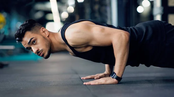 Desportivo jovem árabe homem fazendo chão empurrar para cima exercício no ginásio — Fotografia de Stock