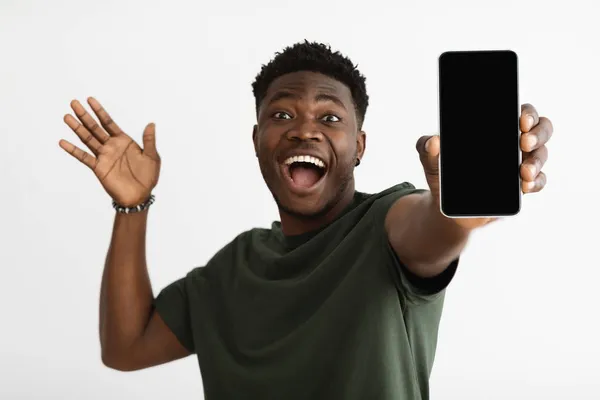 Smartphone con pantalla en blanco en la mano del hombre negro emocional — Foto de Stock