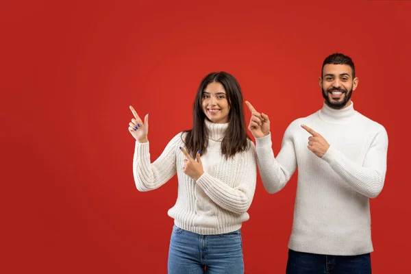 İnanılmaz bir satış. Pozitif Arap erkek ve kadın parmaklarını yana uzatıp kameraya bakıyor, boş alan gösteriyor. — Stok fotoğraf