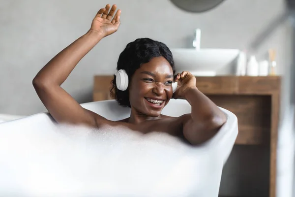 Gelukkig zwart dame nemen bad en luisteren naar muziek — Stockfoto