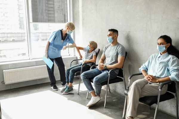 Female doctor greeting teen boy patient with elbow bump — Stock Photo, Image