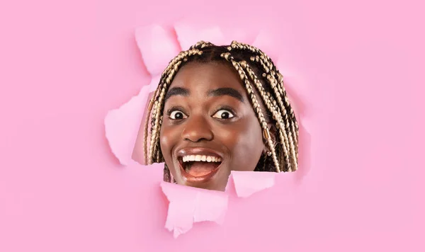Divertido sonriente millennial africana americana mujer mira a través de agujero en papel rosa, collage, panorama —  Fotos de Stock