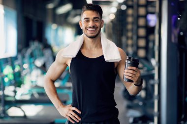 Alıştırma yaptıktan sonra spor salonunda poz veren yakışıklı Arap erkek sporcu