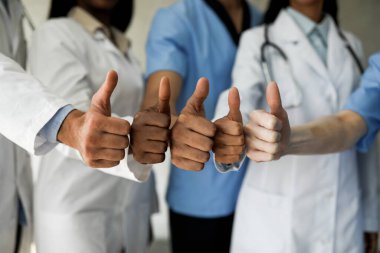 Tanımlanamayan çok ırklı doktorlar baş parmak kaldırıyor.