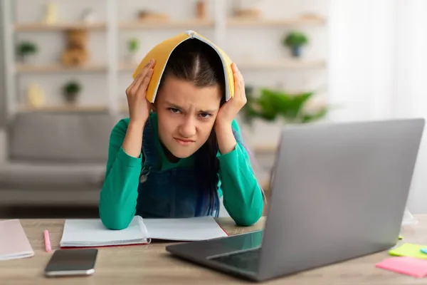Злий стрес дівчина-підліток тримає блокнот на голові — стокове фото