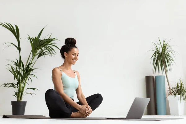 Yoga en línea. Hermosa mujer joven que practica la meditación con el ordenador portátil en casa —  Fotos de Stock