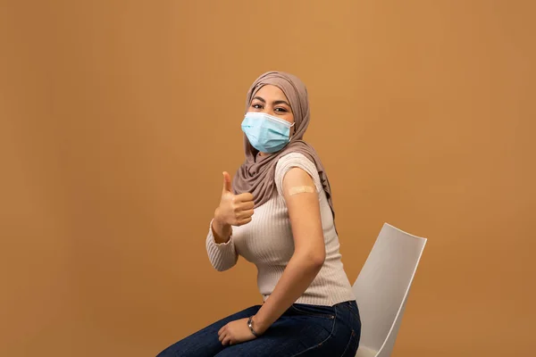 Covid-19 aşısı. Genç tesettürlü Müslüman kadın Coronavirus aşısından sonra kolunu gösteriyor. — Stok fotoğraf