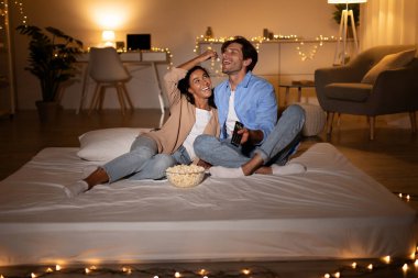 Televizyon seyreden çift evde patlamış mısır yiyor.