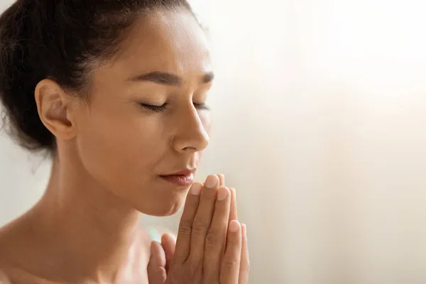 Retrato de mulher morena calma orando ou meditando com olhos fechados — Fotografia de Stock