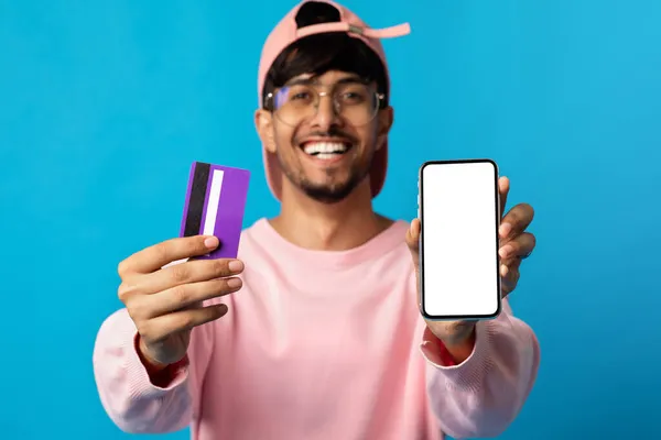 Sorrindo cara elegante mostrando smartphone e cartão de crédito, mockup — Fotografia de Stock