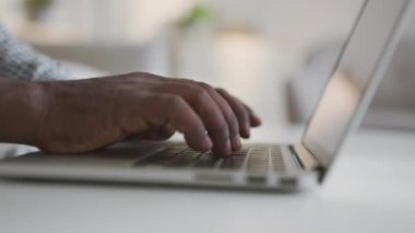 Tanımlanamayan Afro-Amerikan bir adamın dizüstü bilgisayarda yazı yazışının yakın plan çekimi, izleme çekimi, yan görüş, yavaş çekim