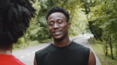 İki genç siyahi adam dışarıda konuşuyor ve gülüyor.