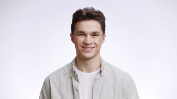 Joyful mood. Studio portrait of young positive man laughing out loudly, enjoying funny joke over white background — Stock Footage Joyful mood. Studio portrait of young positive man laughing out loudly, enjoying funny joke over white background Video Clip