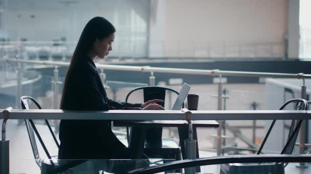 Азиатская предпринимательница с помощью ноутбука работает онлайн в Office Center, Side-View — стоковое видео