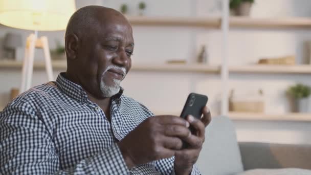 Senior people and modern technologies. Positive senior man web surfing on smartphone, enjoying online communication — Stock Video