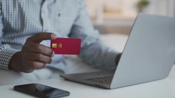 Online banking. Uomo afroamericano irriconoscibile che effettua transazioni internet con carta di credito e laptop a casa — Video Stock