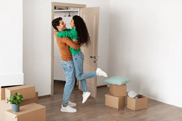Feliz casal milenar celebrando dia em movimento em novo apartamento — Fotografia de Stock