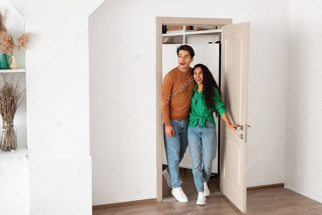 Portrait of excited emotional couple walking in their apartment