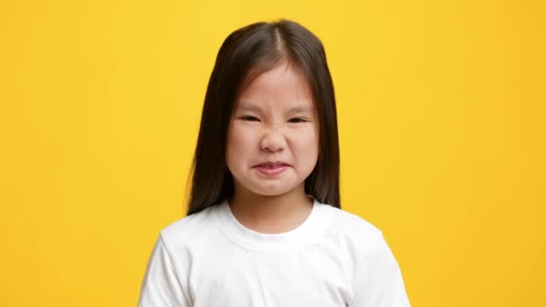 Nojento japonês menina beliscando nariz cheirando cheiro desagradável, fundo amarelo — Vídeo de Stock