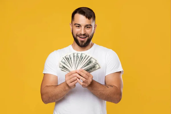 Emocionado hombre europeo de mediana edad feliz se regocija con la victoria y mira un montón de dinero en las manos —  Fotos de Stock