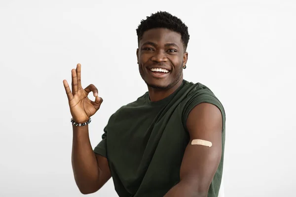 Lächelnder afrikanisch-amerikanischer Patient wurde geimpft und zeigt Okay — Stockfoto