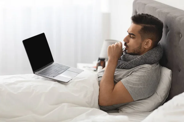 Sick Arab Man Using Laptop Computer While Sitting In Bed At Home — Stock Photo, Image