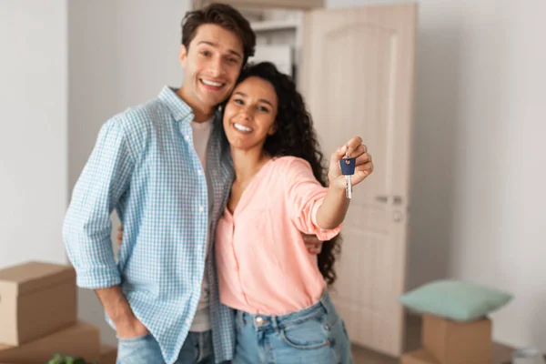 Happy man and woman posing with keys on moving day — Stock Photo, Image