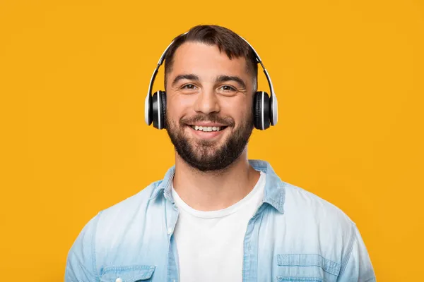 Homem europeu atraente adulto alegre em fones de ouvido ouvindo música favorita — Fotografia de Stock