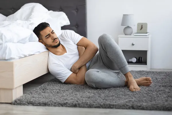 Deprimido perturbado jovem Oriente Médio Homem sentado no chão no quarto — Fotografia de Stock