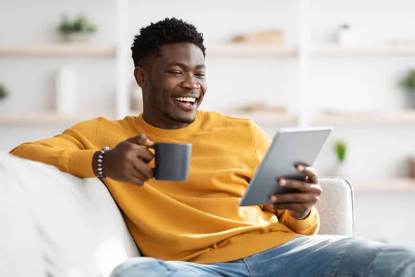 Ontspannen zwarte man zitten op de bank, kijken film online — Stockfoto