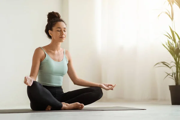 Meditación matutina. Hermosa mujer tranquila meditando en casa en posición de loto —  Fotos de Stock