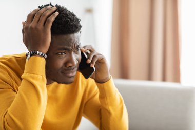 Stresli Afrikalı Amerikalı adam telefon görüşmesi yapıyor, kopyalama alanı var.