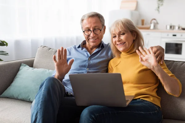 Starší manželé video volání Waving Hello To Laptop At Home — Stock fotografie