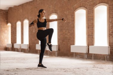 Aktif eğitim. Spor Giyim 'de Atletik Genç Kadın Boş Şehir Binasında Egzersiz Yapıyor