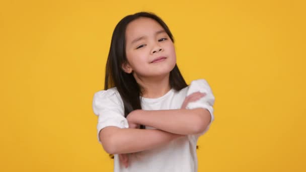 Concepto de aprobación. Cool chica asiática cruzando las manos y asintiendo con la cabeza, expresando ok y acuerdo, fondo naranja — Vídeos de Stock