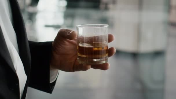 Sprengt bilde av en forretningsmann som holder glass med Whiskey. – stockvideo