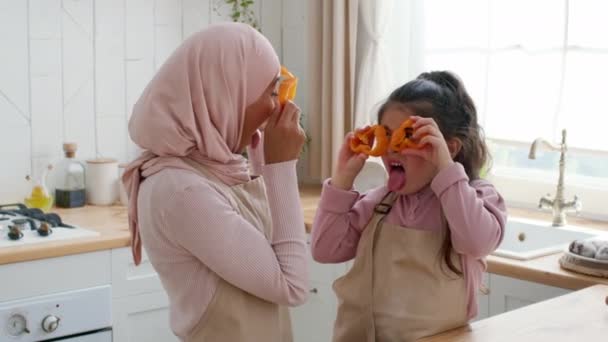 Мусульманська мама і маленька донька веселяться на кухні — стокове відео