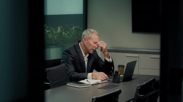 Homme d'affaires senior qui enlève des lunettes souffrant de maux de tête au bureau — Video
