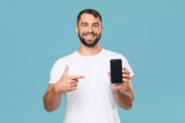 Gülümseyen yetişkin Avrupalı adam parmağını akıllı telefona gösteren boş ekran, sunum aygıtı