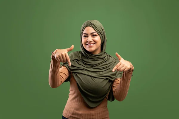Lihat di sana. Wanita arab positif menunjuk ke bawah dengan dua jari, menunjukkan tempat bebas untuk desain atau iklan — Stok Foto
