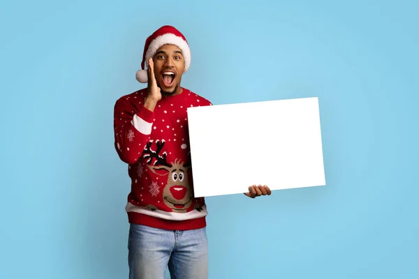 戴着圣诞帽拿着空广告牌的令人惊讶的黑人 — 图库照片