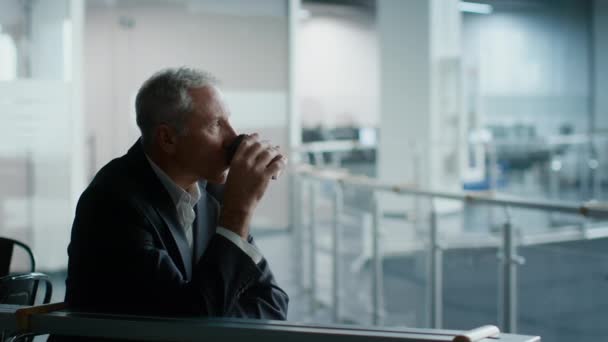 Empresário sênior bebendo café olhando para o centro de escritório moderno interior — Vídeo de Stock