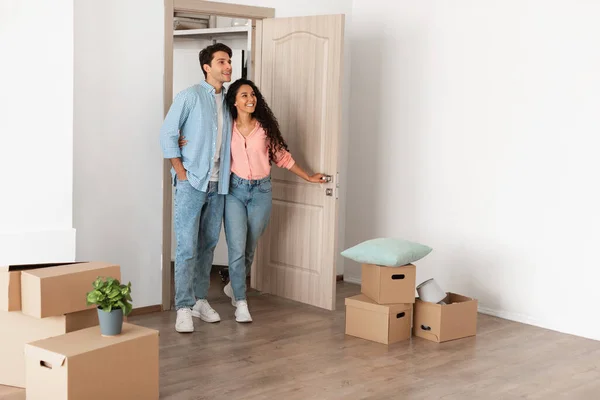 Feliz pareja emocionada caminando en casa nueva — Foto de Stock