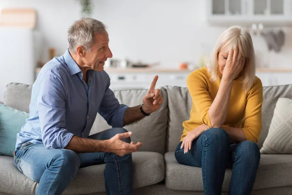 Naštvaný starší manžel křičí na uraženou ženu, která má Quarrel uvnitř — Stock fotografie
