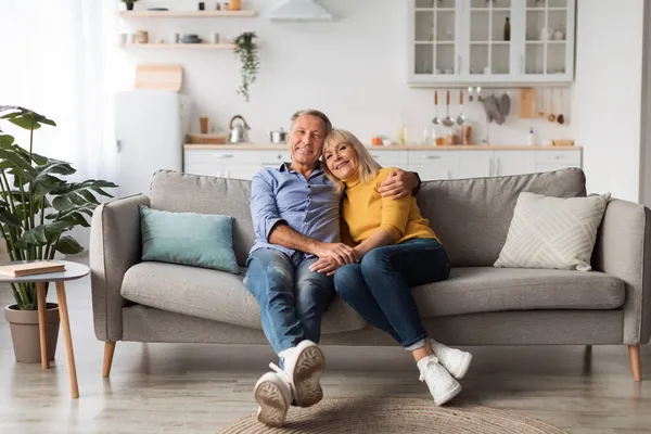 Щаслива зріла пара приймає позування сидячи на дивані вдома — стокове фото