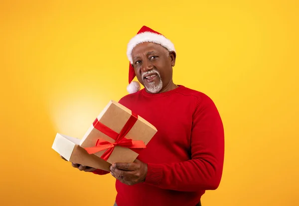 Feliz hombre negro senior en Santa sombrero de apertura de regalo de Navidad con luz de hadas, recibiendo el regalo deseado para la Navidad — Foto de Stock