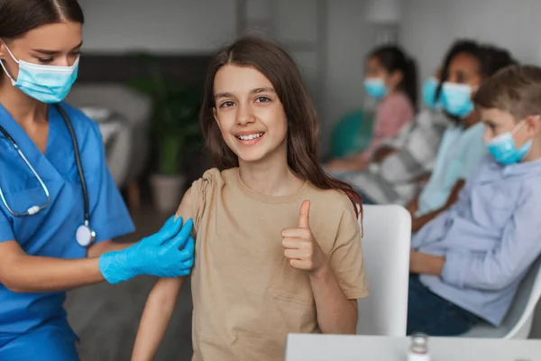 Happy Vaccinated Girl Gesturing Thumbs Up Approving Antiviral Vaccine Indoor — Stock fotografie