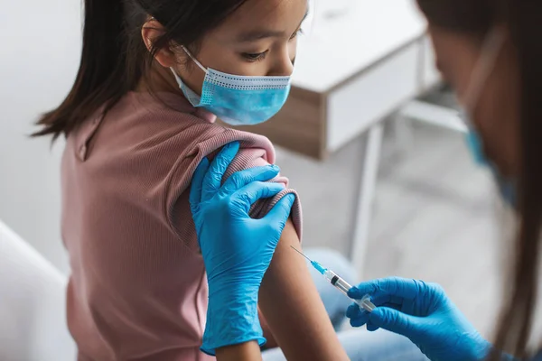 Медсестра Ін'єкція Ковід-19 вакцина проти вакцинації Корейська маленька дівчинка сидить в приміщенні — стокове фото