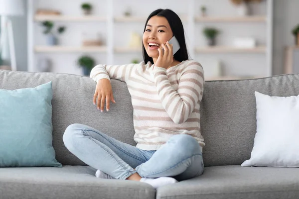 Mobiele communicatie. Portret van mooi aziatisch vrouw praten op mobiele telefoon thuis — Stockfoto